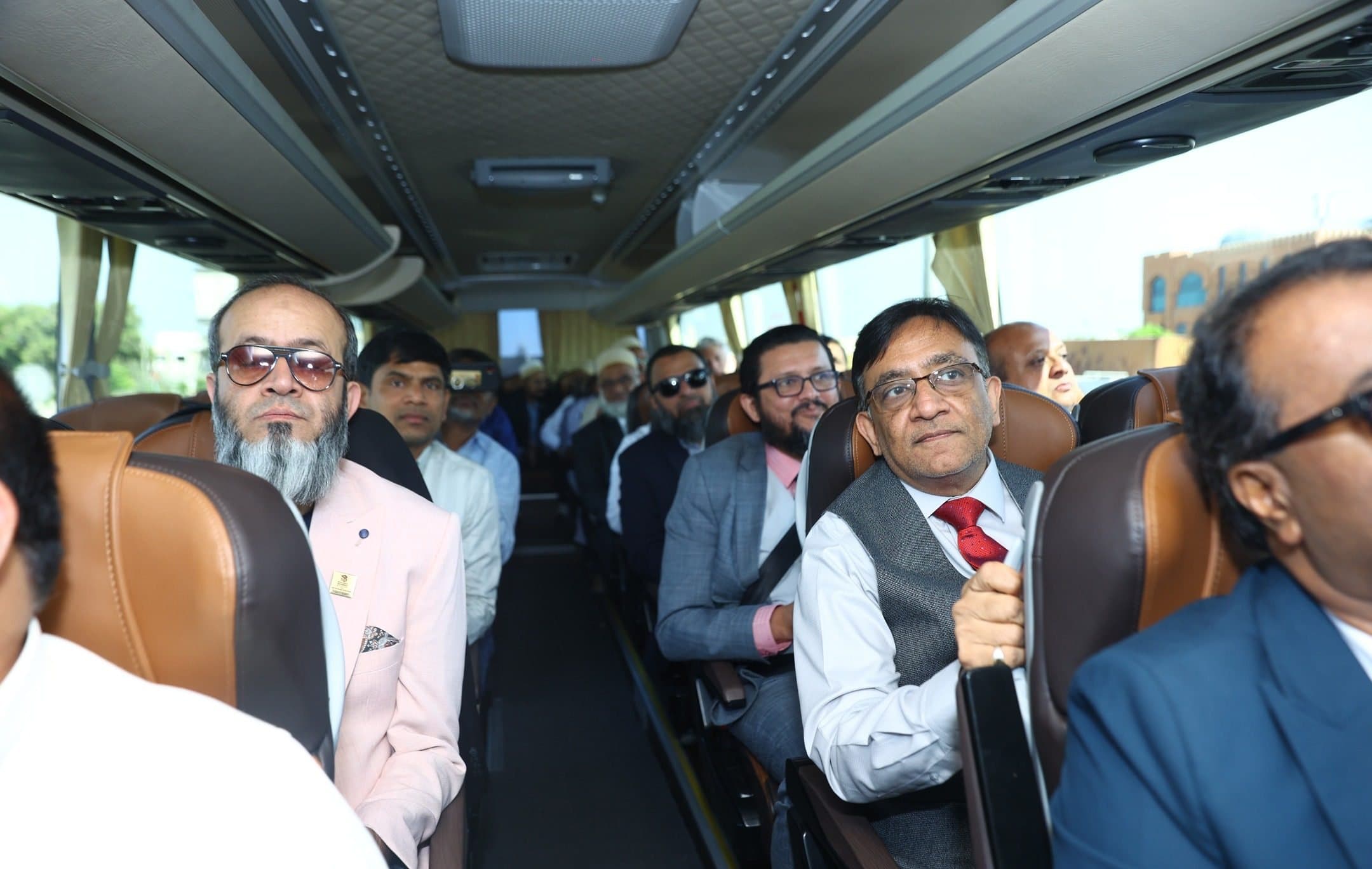 RAK Build Connect: Members seated on a coach, one man in a waistcoat smiling at the camera