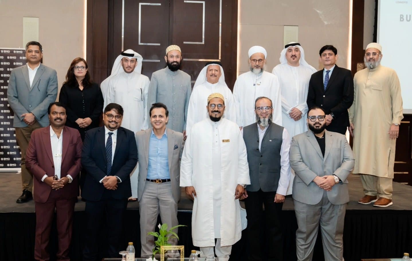 UAE National Day Celebration: Large group of guests in suits and kandura posing in a hotel ballroom