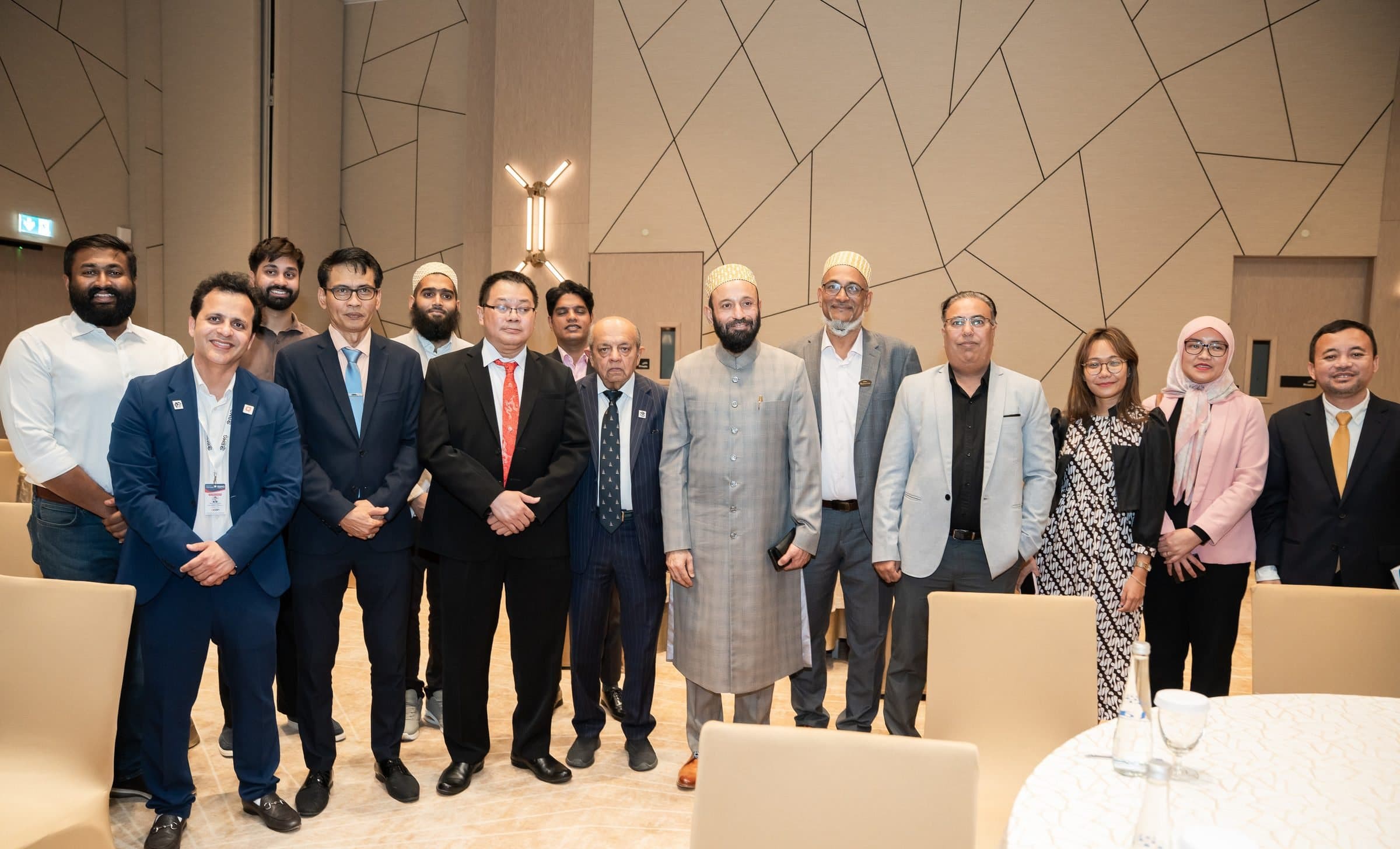 Group of guests posing in a hotel hall with geometric wall panels