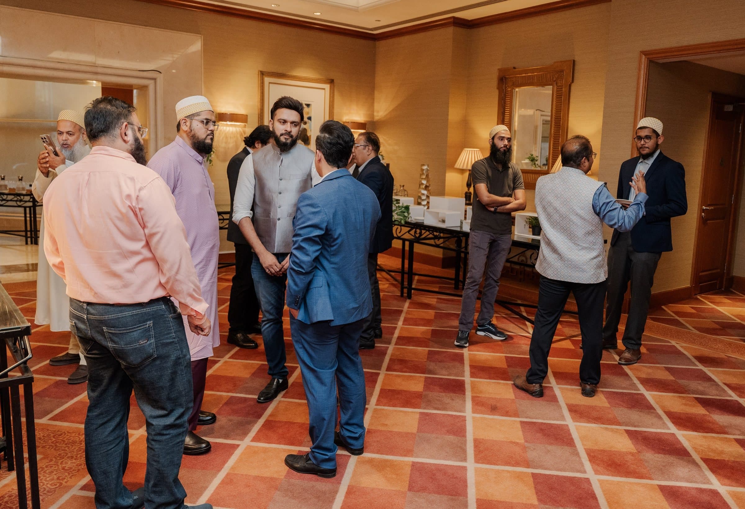 Members' Constructive Conversation: Members standing and talking in small groups on a terracotta tiled floor