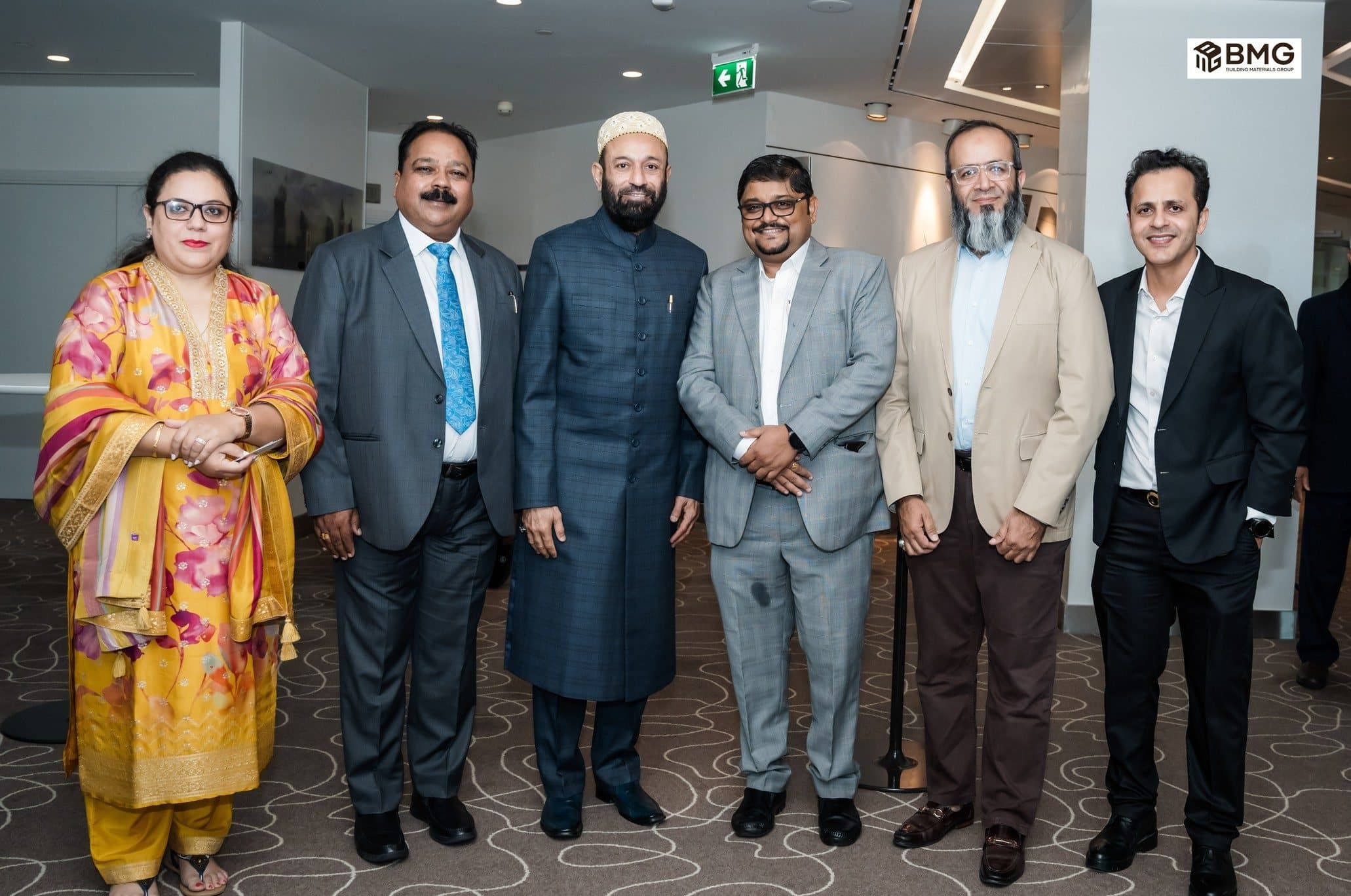 Six guests standing together, a woman in a yellow outfit on the left