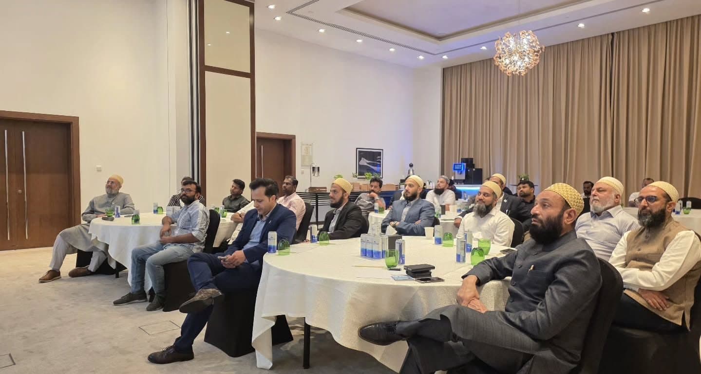 Attendees seated at round tables in a hotel meeting room listening to a talk
